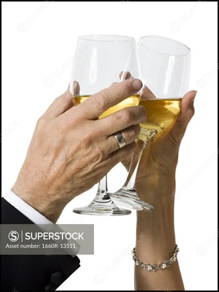 Close-up of two people toasting glasses of wine
