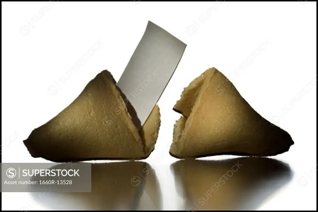 Close-up of a broken fortune cookie with a slip of paper