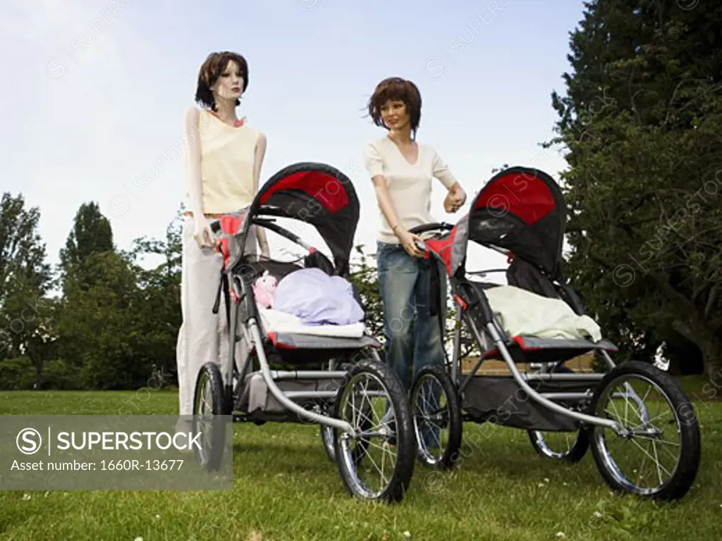 Low angle view of two mannequins portraying mothers pushing prams