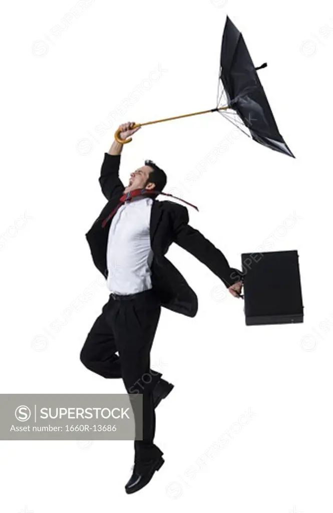 Profile of a businessman holding an umbrella and jumping
