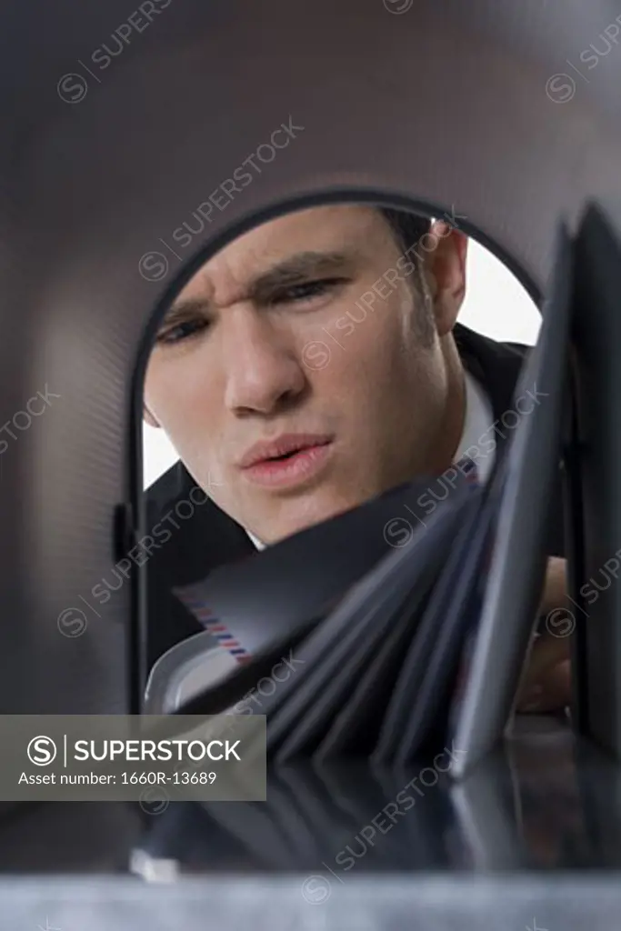 Close-up of a businessman looking into a mailbox