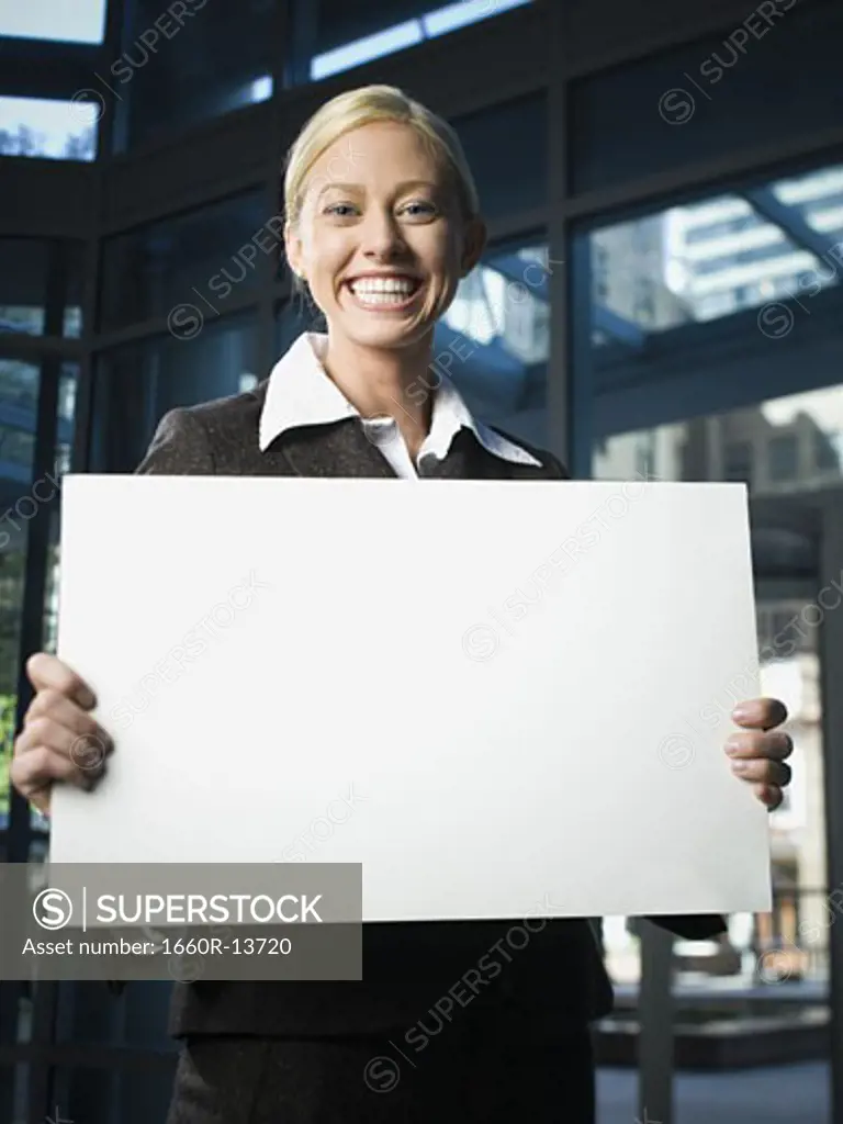 Portrait of a businesswoman holding a blank sign and smiling