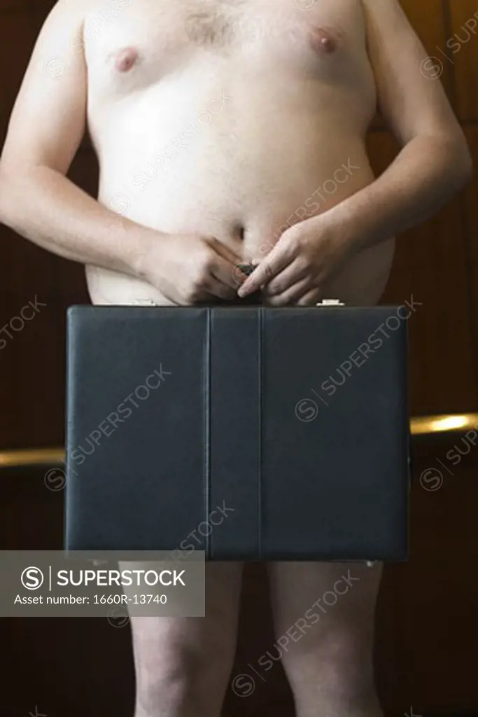 Mid section view of a naked businessman holding a briefcase
