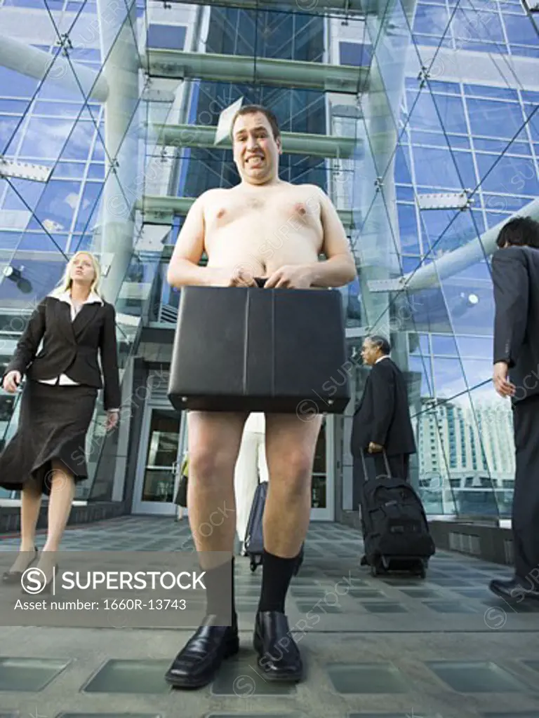 Low angle view of a naked man holding a briefcase