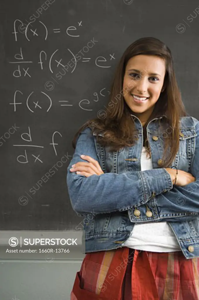Female student leaning against chalkboard