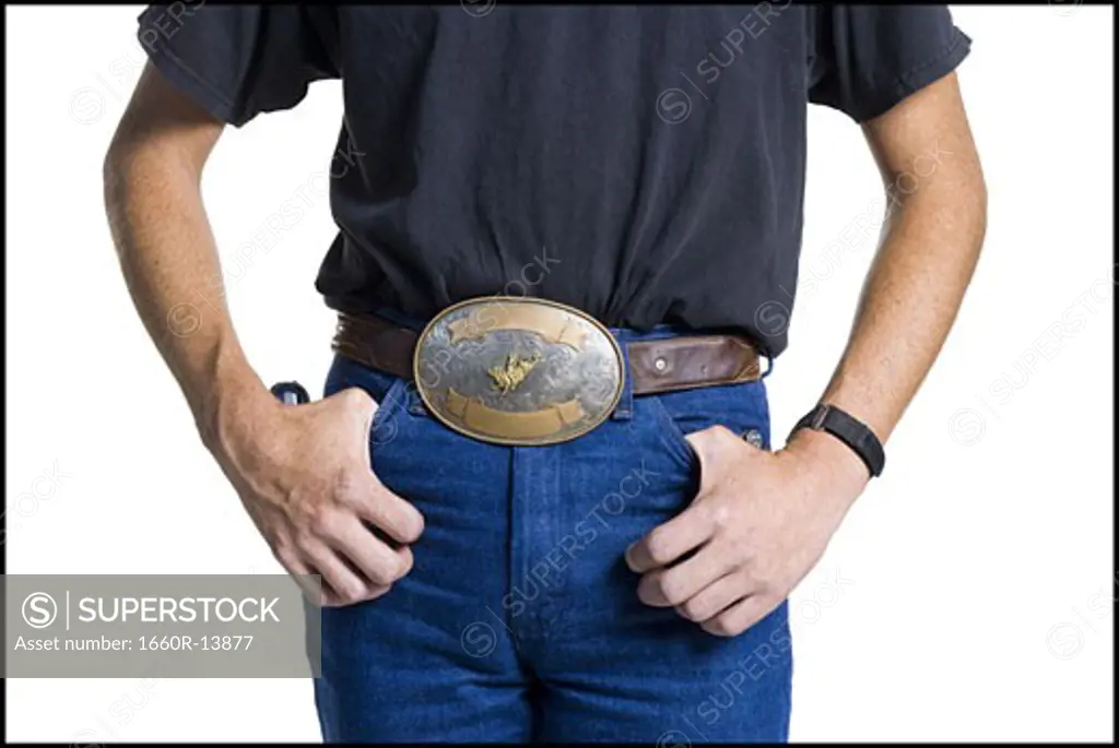 Midsection of slender young man wearing a big belt buckle