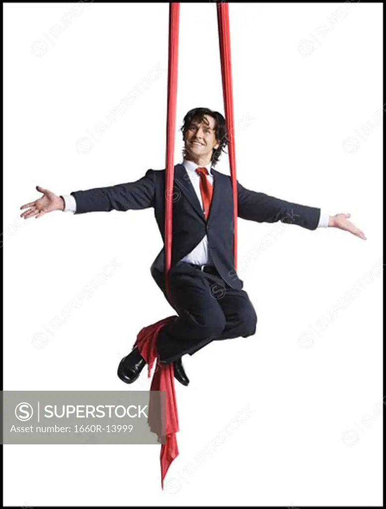 Businessman tangled in red drapes