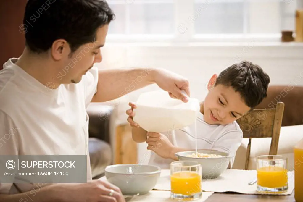 Father and young son having breakfast together