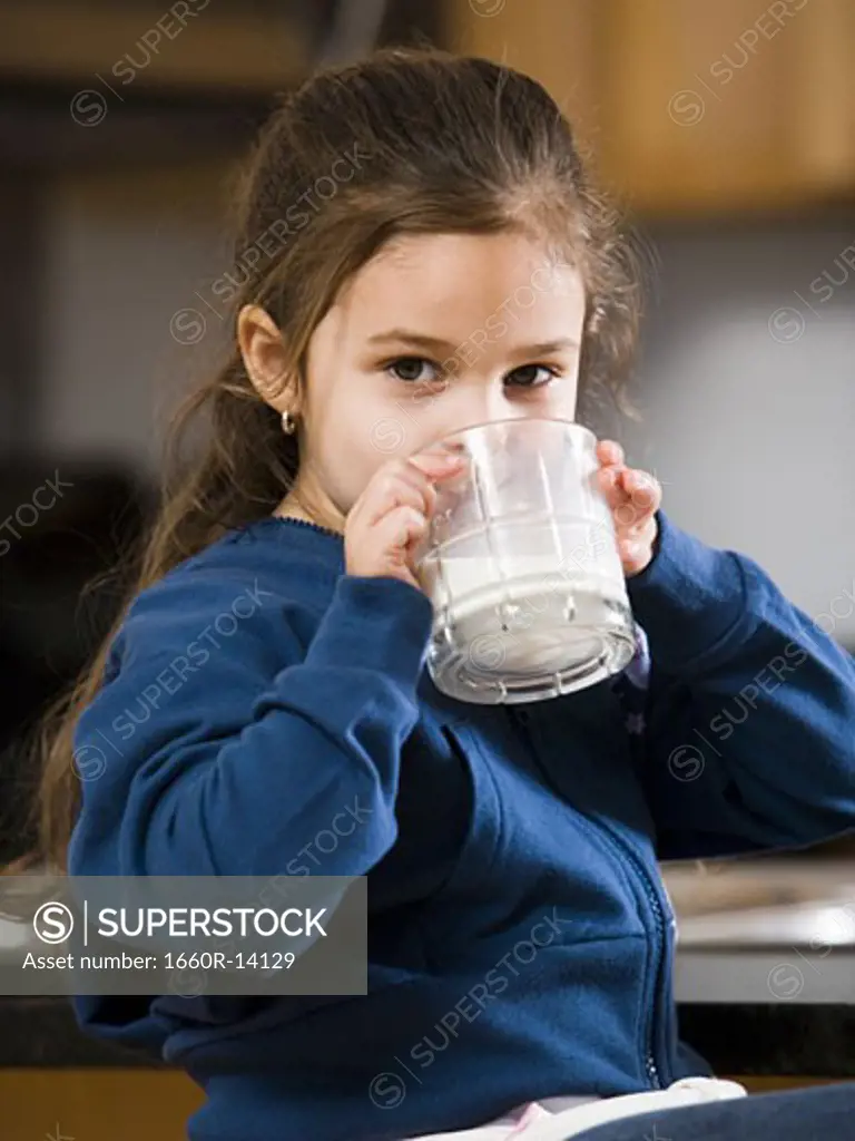 Young girl drinking a glass of milk