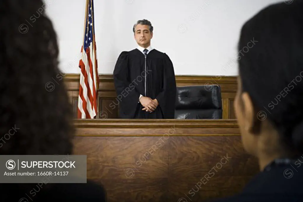 Judge standing in front of defendants and lawyers