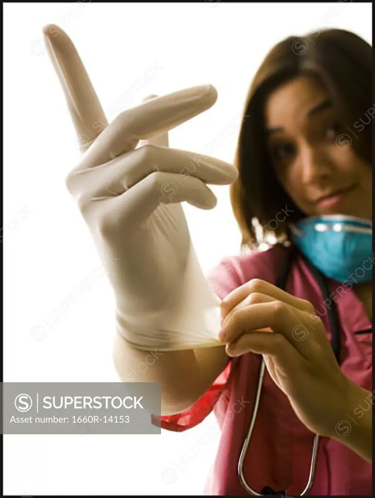 Female doctor in pink scrubs with rubber glove