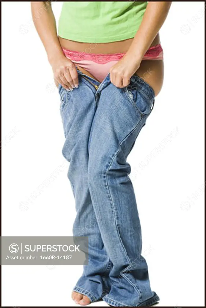 Young woman having trouble getting into pants