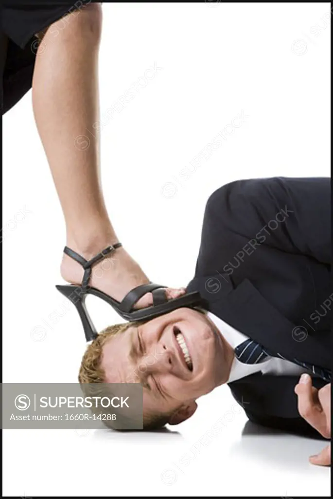 Woman stepping on man's head