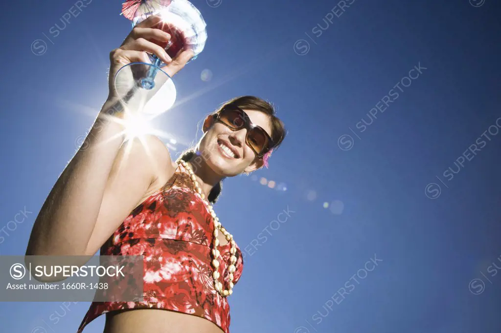Low angle view of a mid adult woman holding a cocktail