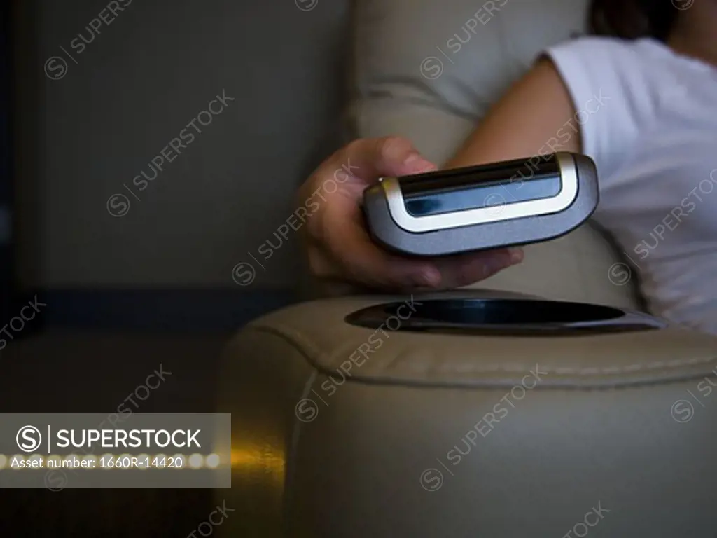 Hand holding remote control in home theater