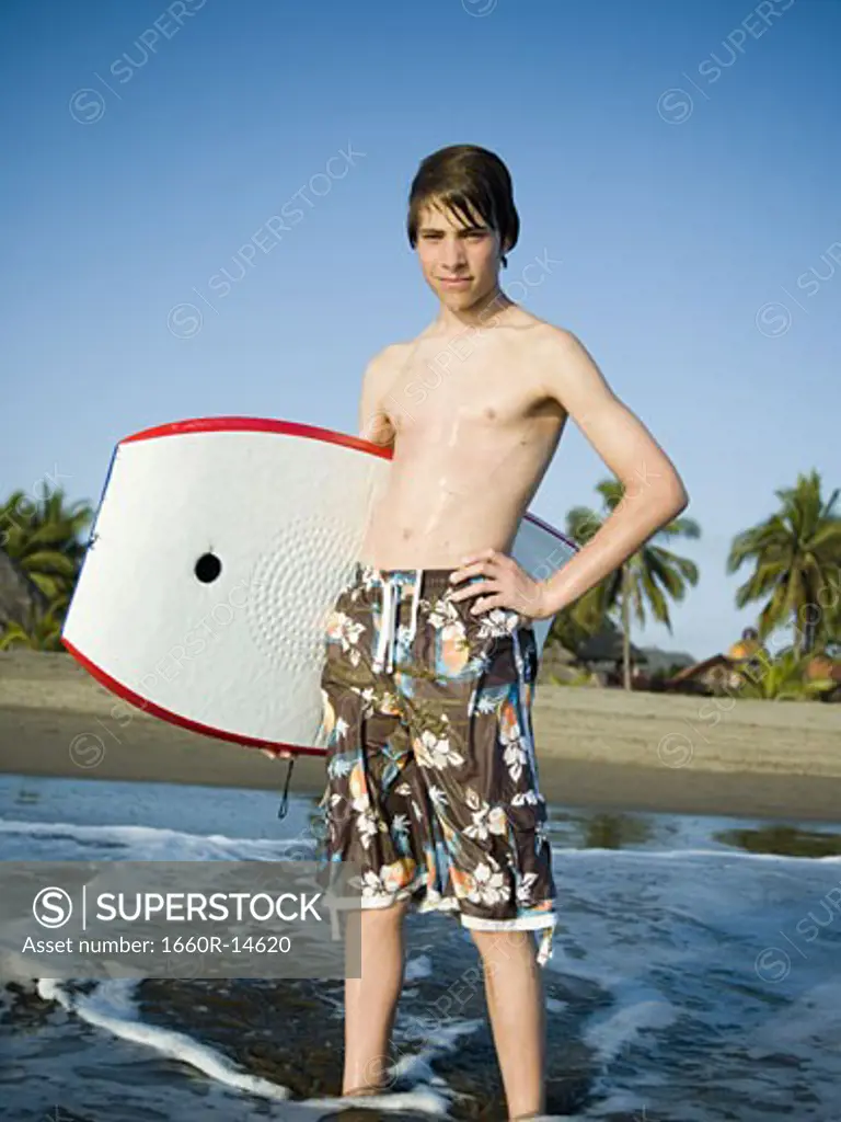 Boy at the beach with a boogie board