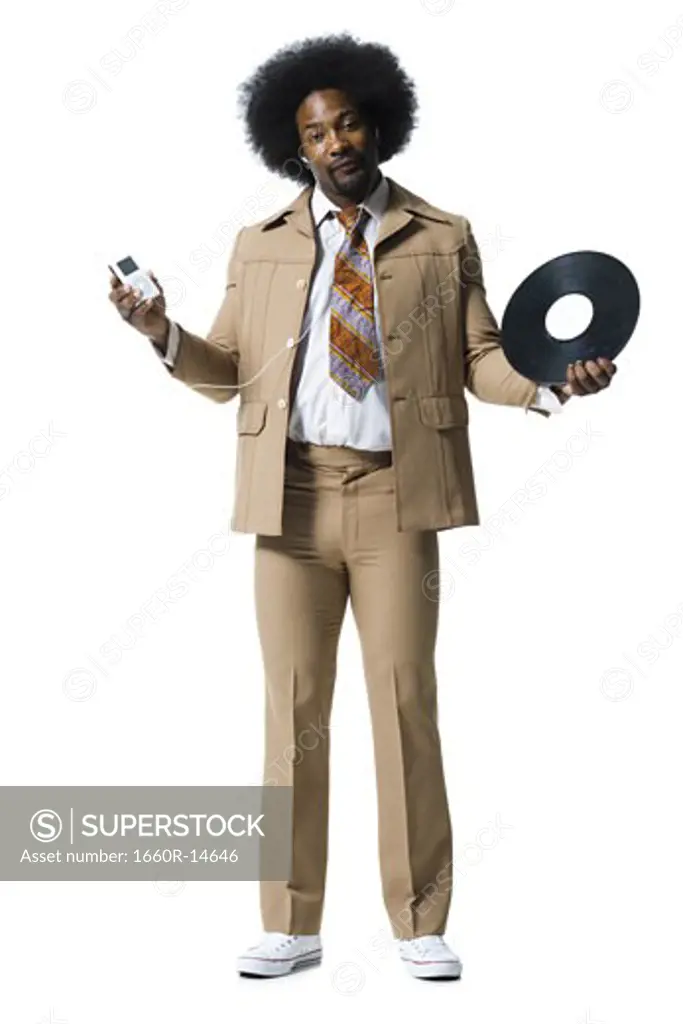 Man with an afro in beige suit listening to MP3 player