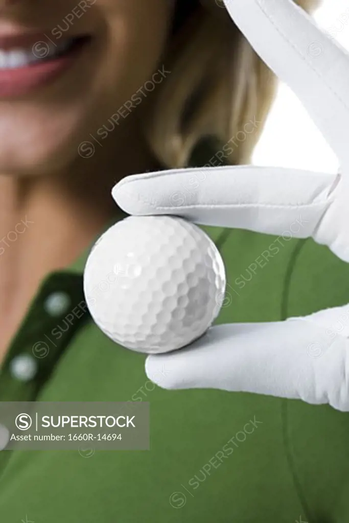 Female golfer and close-up of golf ball