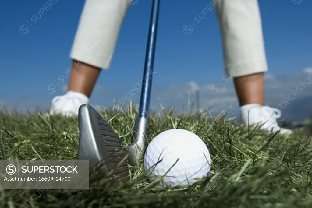 Female golfer and close-up of golf ball