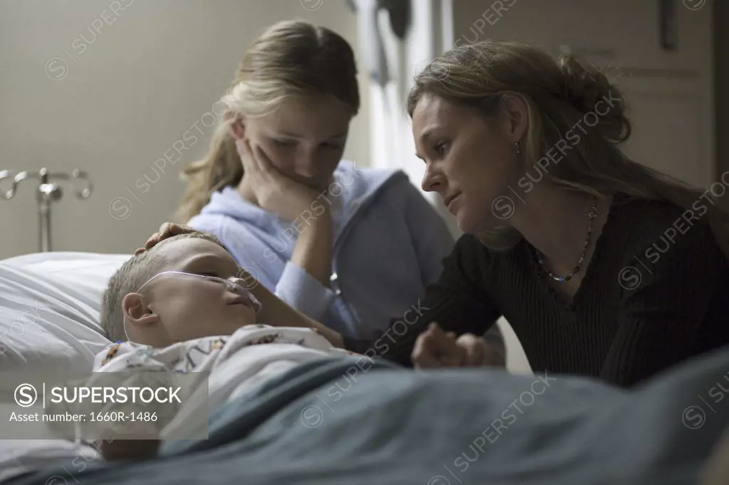 Mother and her daughter consoling her son in the hospital