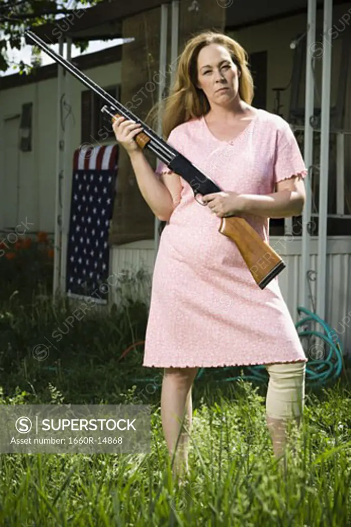 Woman in trailer park with shotgun
