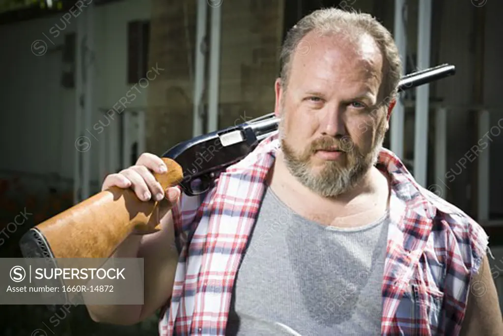 Overweight man with a shotgun