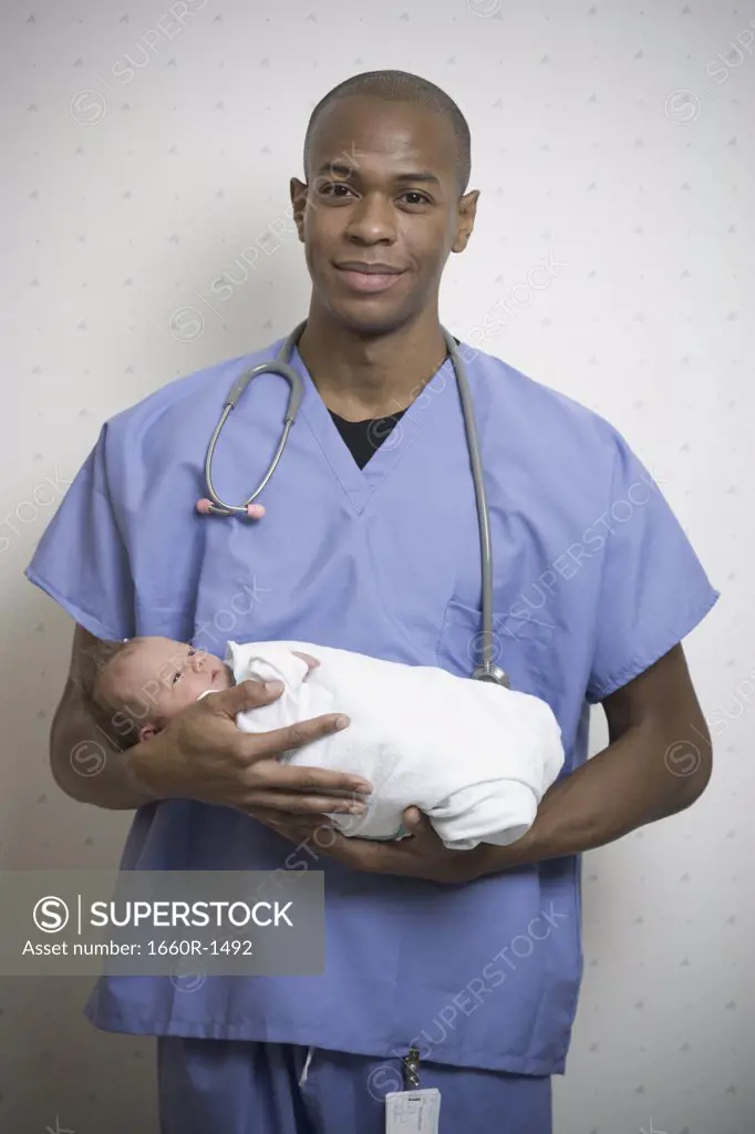 Portrait of a male doctor holding a baby boy