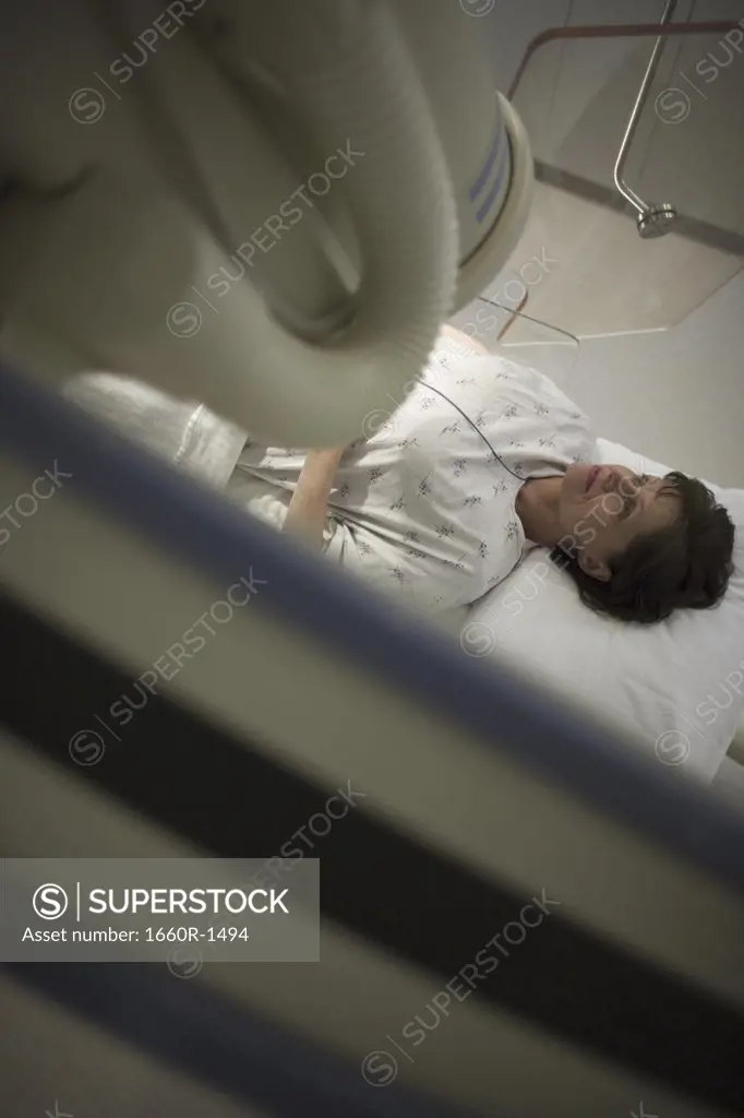 High angle view of a female patient lying under an X-Ray machine