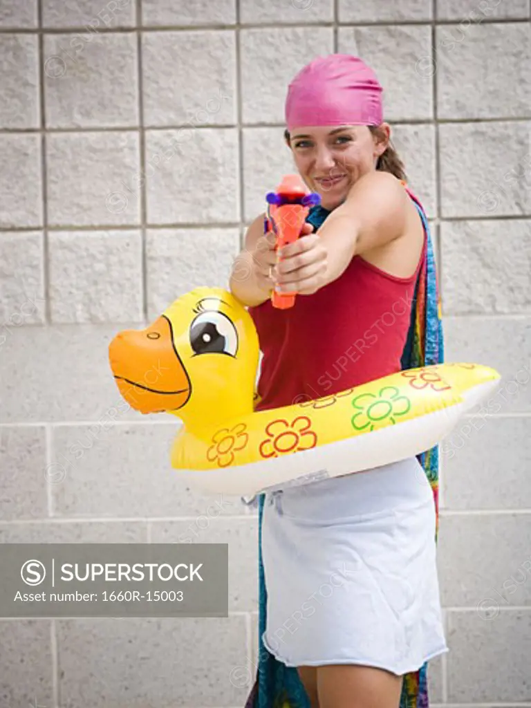 Girl at swimming pool with life ring and water pistol