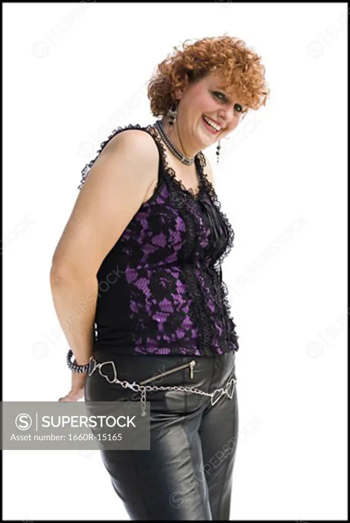 Smiling woman with red hair in leather pants