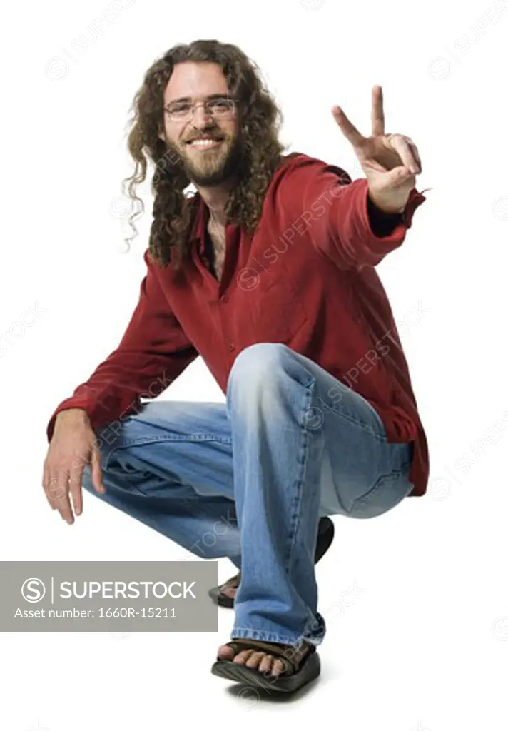Man with long hair and beard making peace gesture