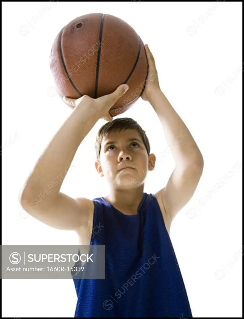 Boy playing basketball and taking a shot