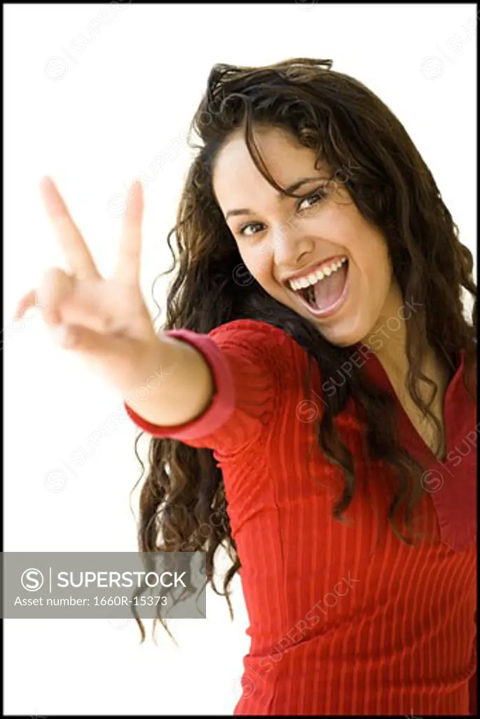 Woman in red shirt making peace gesture