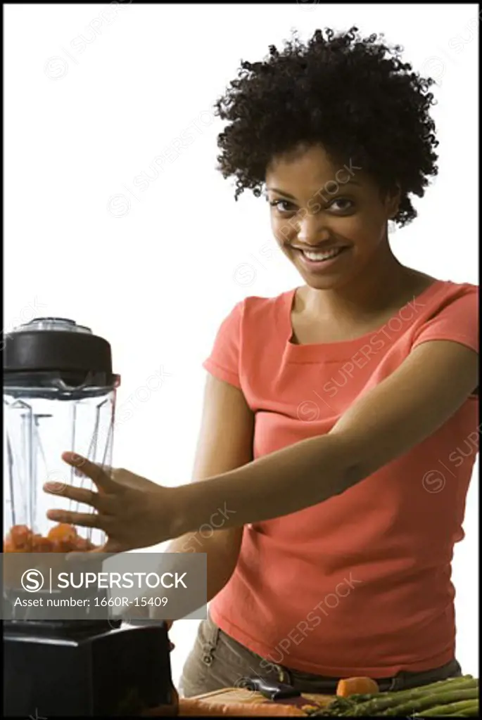 Woman with carrots in a blender