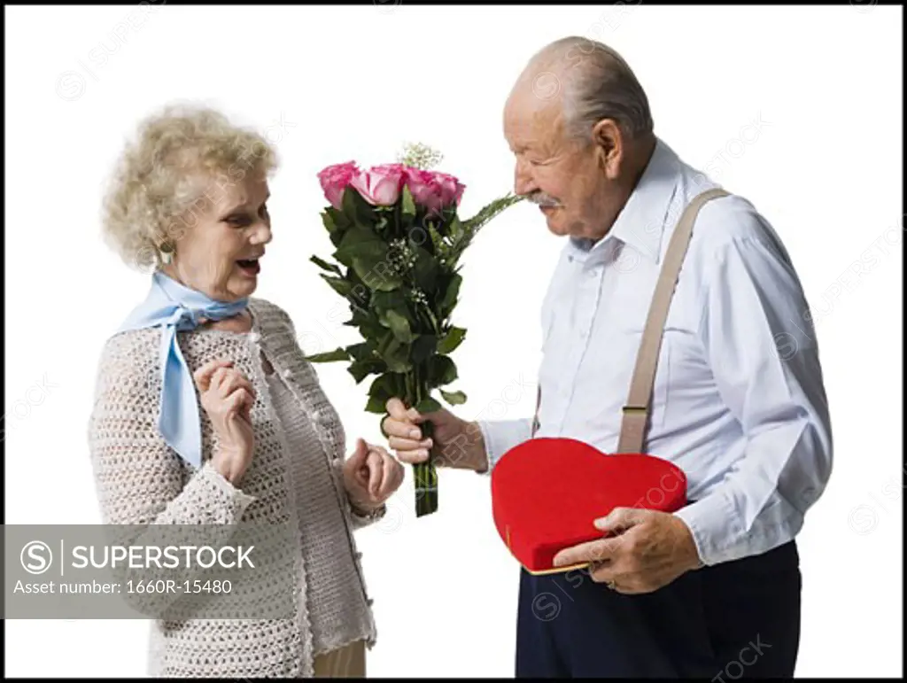 Older man giving wife Valentines chocolate