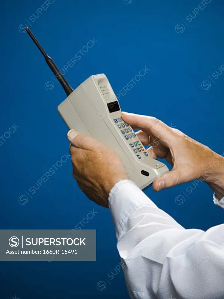 Older man making call on retro wireless phone