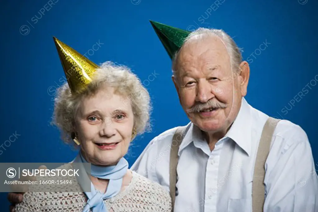 Older couple wearing party hats