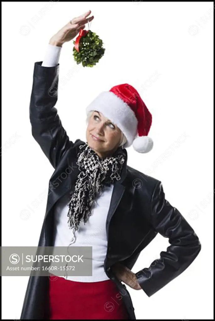 Woman wearing Christmas hat under mistletoe