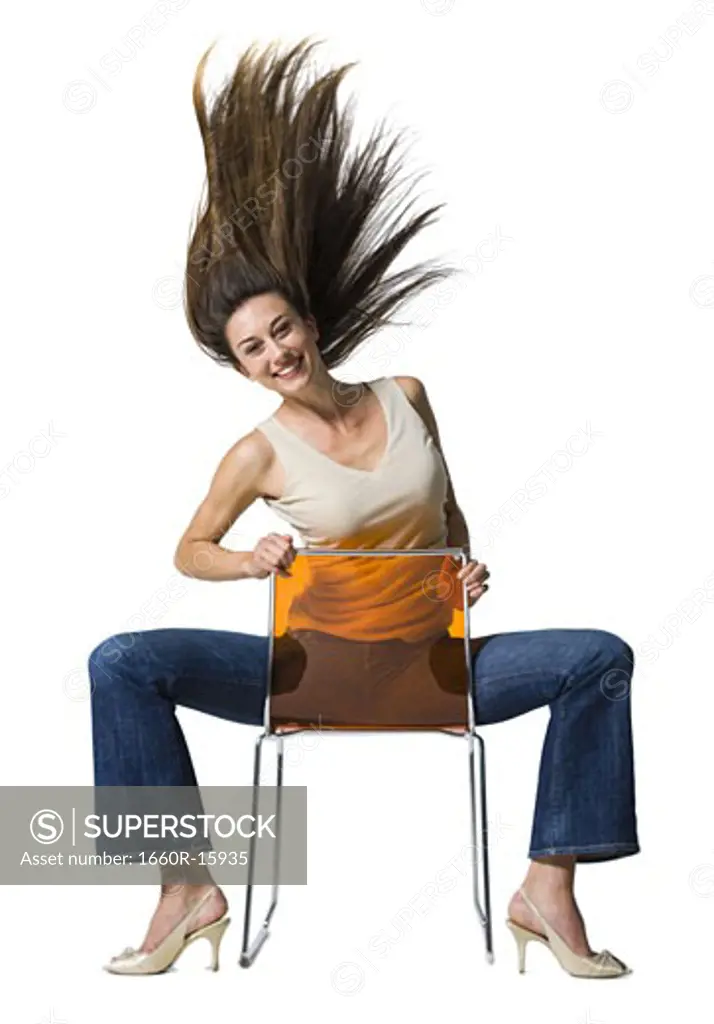 Woman sitting backwards on chair and tossing hair