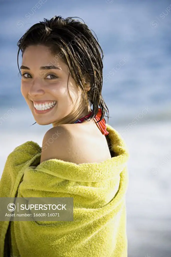 Woman on beach wrapped in a towel