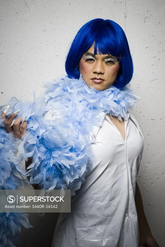Man in blue wig and feather boa flirting