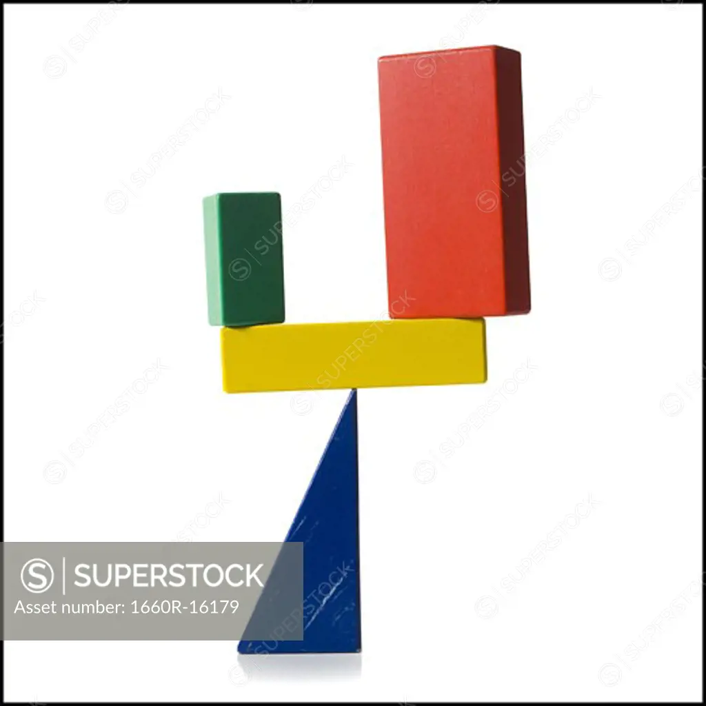 Wooden blocks precariously balancing on triangle