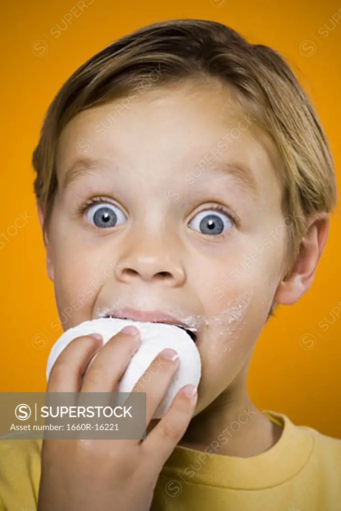 Boy with blue eyes eating donut
