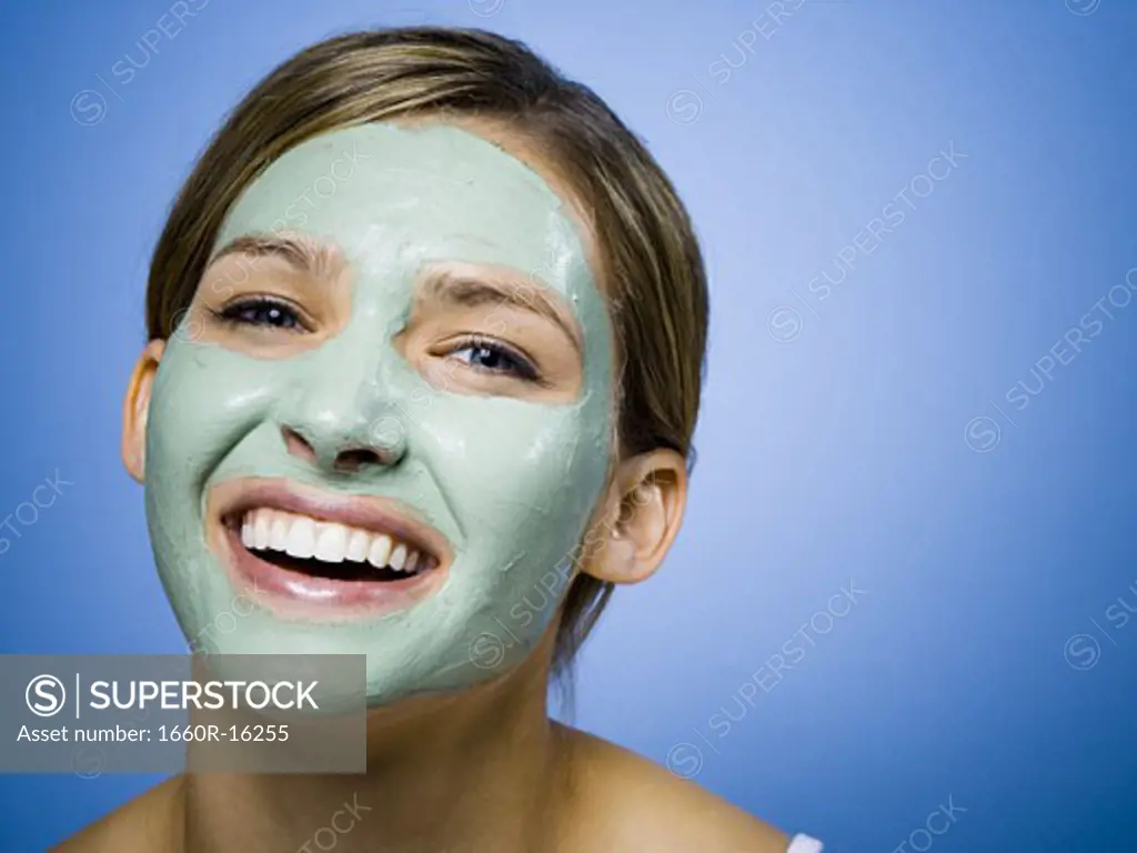 Woman with facial mask smiling with copy space