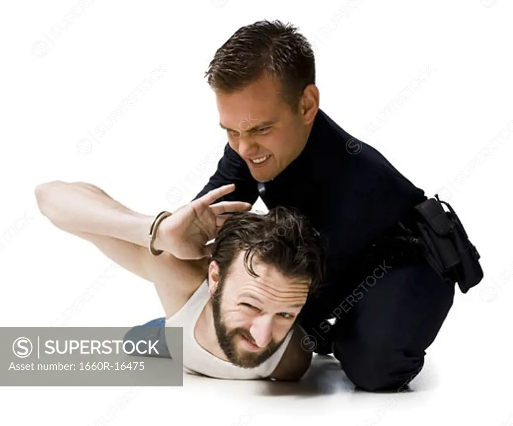 Police officer arresting man lying down with handcuffs