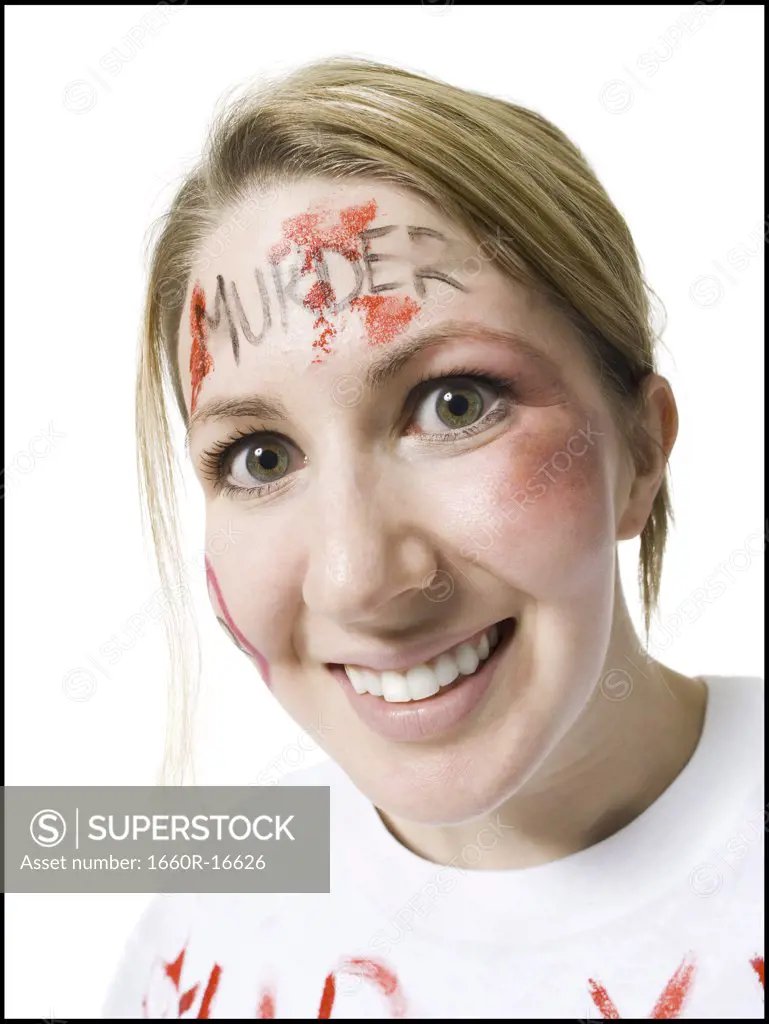 Closeup of woman with Murder on forehead