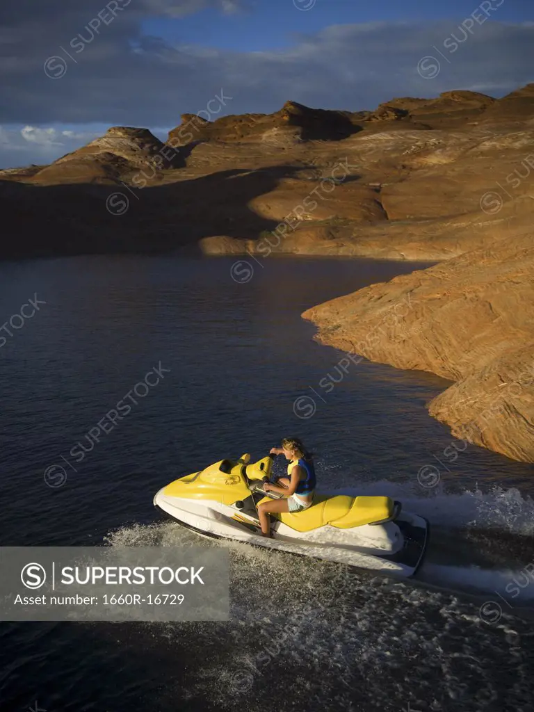Woman on personal water craft with rock formations