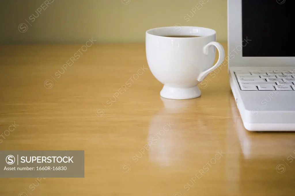 Close-up of laptop computer and coffee cup