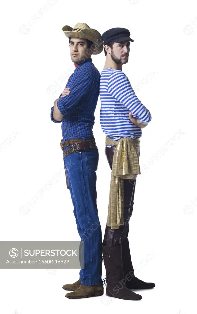 Man in cowboy costume and man in leather pants with waist sash standing back to back