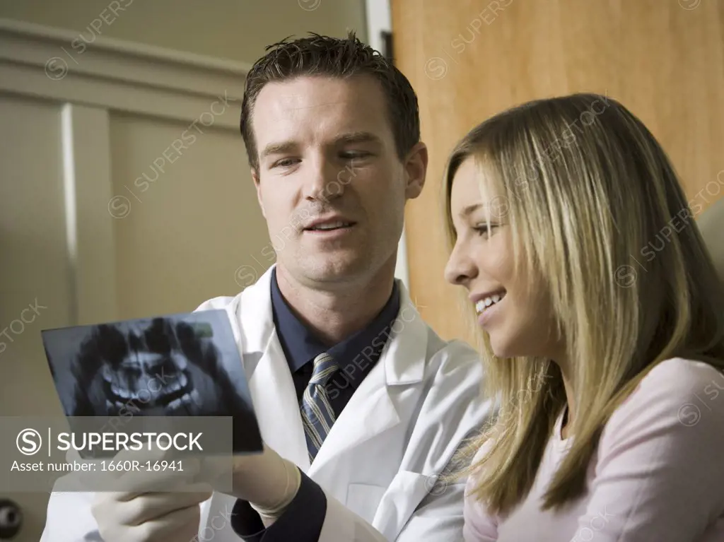 Dentist looking at x-rays with girl